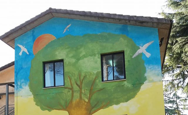La parete della Scuola dell'Infanzia ospita il murale "L'albero che suona" di Salvatore Ravo