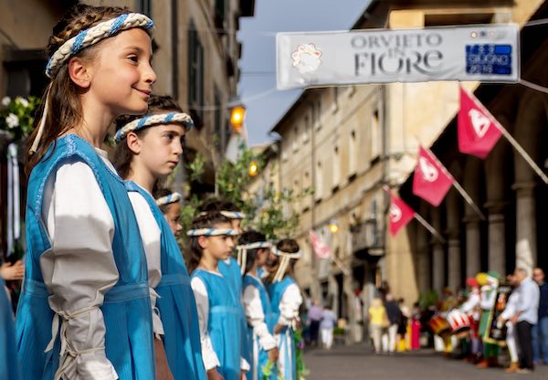 "Fiori e bandiere, alle finestre e nelle vetrine, con i colori dei quartieri"