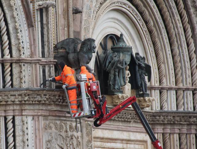 Tecnici al lavoro per pulire la facciata del Duomo