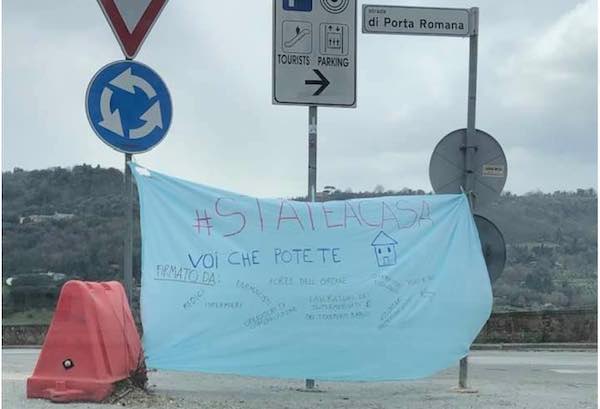 "State a casa voi che potete". Striscione lungo la Strada di Porta Romana